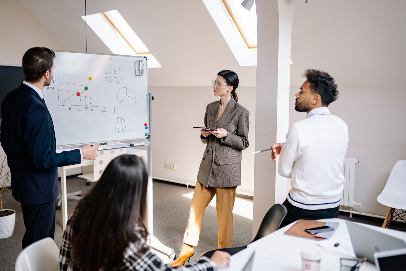 A team reviewing strategy charts on a whiteboard